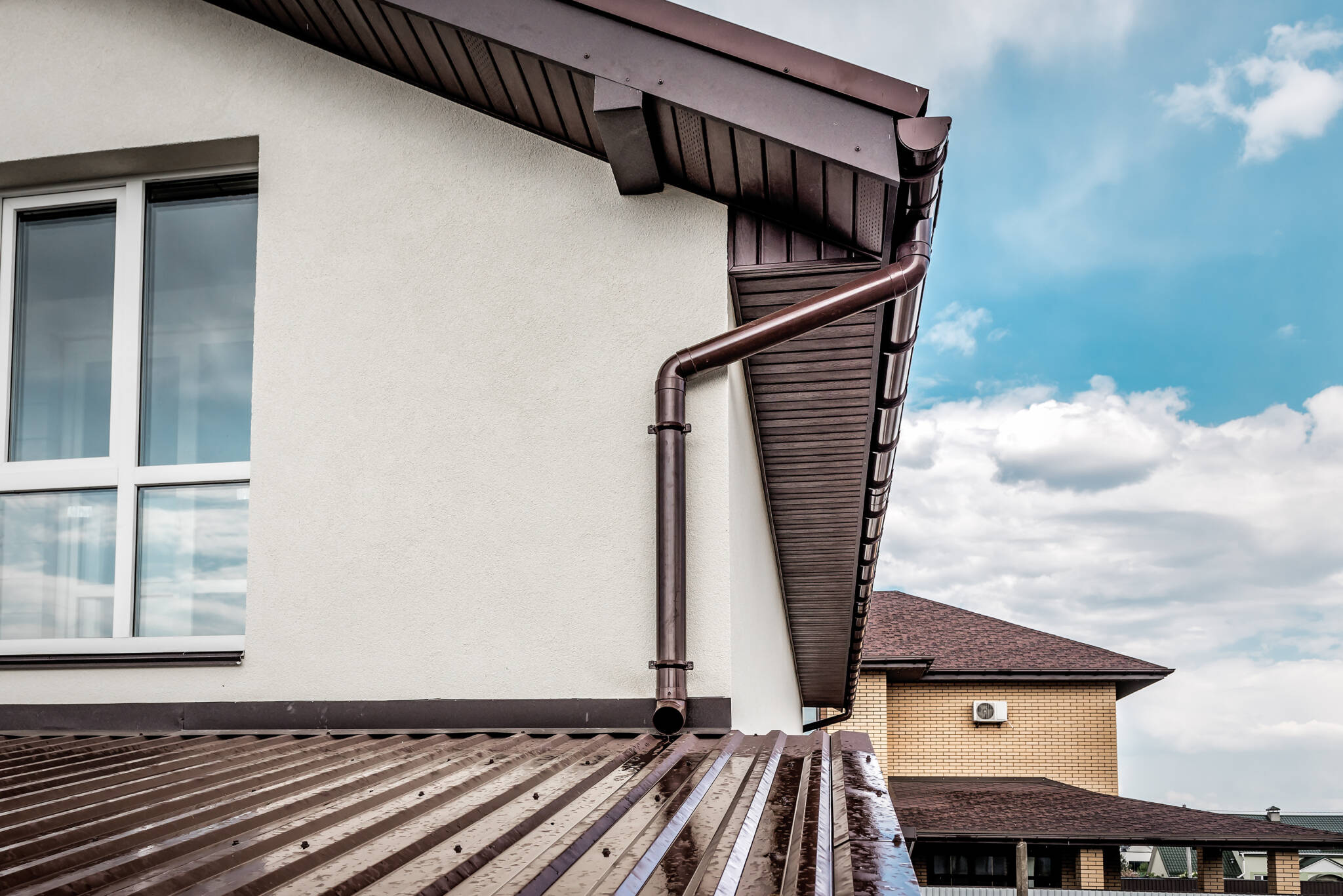 Wet Roof And Metal Brown Gutter Of Brick House In Summer Season