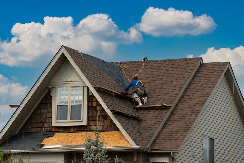 Roofing contractor repairing a residential roof for Tither Roofing and Construction